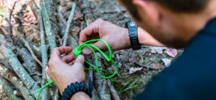 Person tying a paracord knot