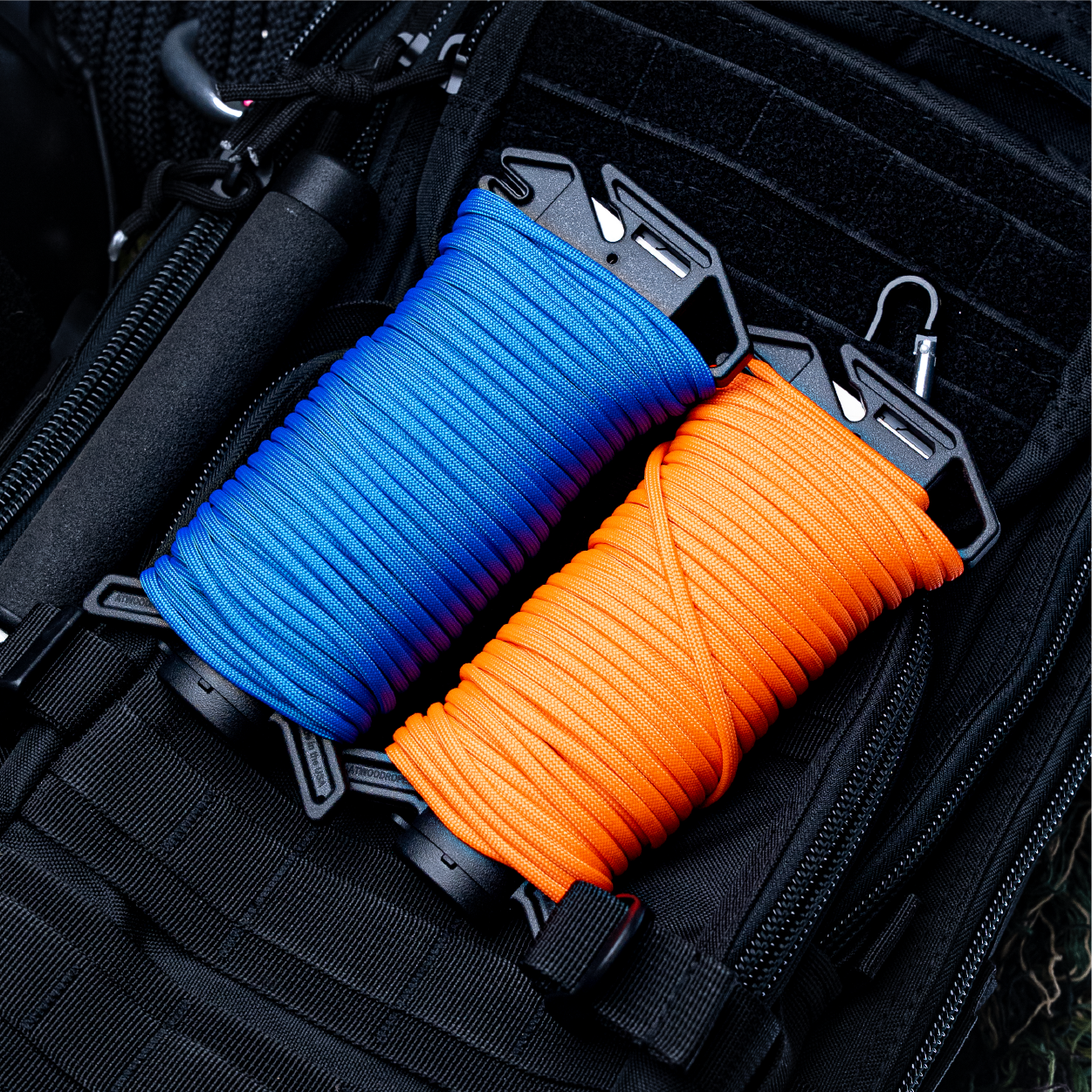 Two Ready Ropes, one loaded with blue and one neon orange paracord on backpack